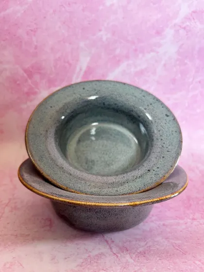 Two pasta bowls stacked, showing their uniform shape and the subtle variations in the glaze.
