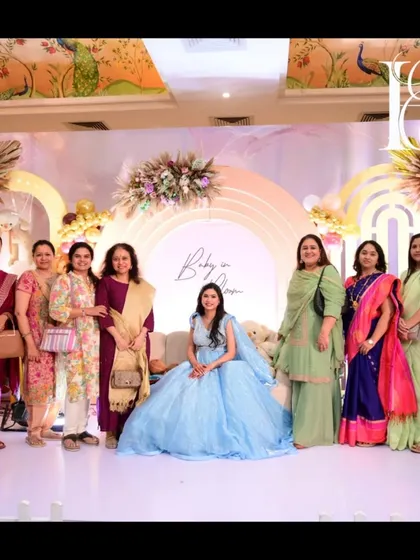 A group photo of guests with the mom-to-be on the decorated stage. The wide backdrop and spacious platform provide an ideal setting for capturing memories with friends and family during the celebration.