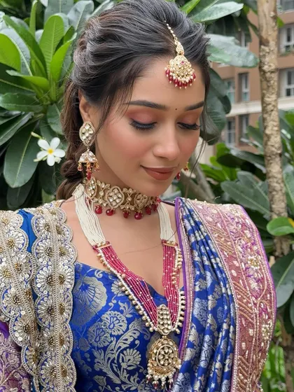 This angle showcases the stunning multi-layered necklace and how the makeup tones complement the jewelry.