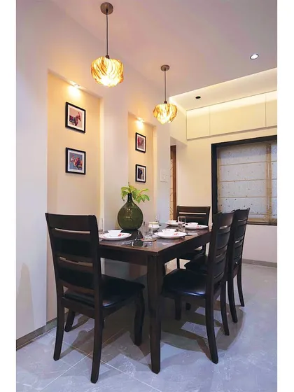 We believe in giving new life to old treasures. This client's existing wooden dining set was seamlessly integrated into the new design, complemented by modern pendant lights and wall niches for family photos.