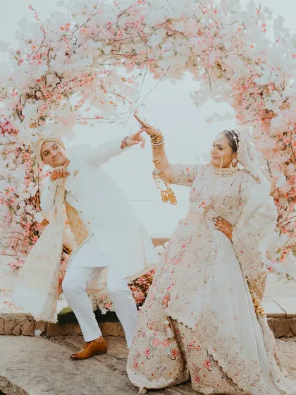 Another fun, dancing pose from the couple in front of their beautiful floral arch. These shots are perfect for showing the couple's personality and the joyful vibe of their wedding.