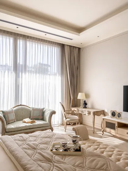 This bedroom in The Ivory Royale is a sanctuary of classic elegance. Vintage-style furniture, a tufted headboard, and soft, luxurious fabrics create a story of timeless comfort. It is a space where morning comes with quiet hope and night arrives with deep thoughts.