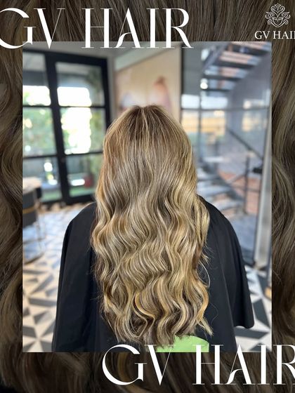 The hair glow-up is real. This beautiful blonde balayage on long, wavy hair is a perfect example of a dramatic yet seamless transformation.