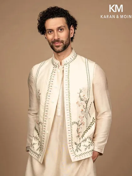 The Nehru jacket is a cornerstone of a versatile wardrobe. This ivory piece showcases my commitment to detail, with intricate floral embroidery that is both delicate and distinct. It is crafted to be layered, transforming a simple kurta into a statement of effortless sophistication.