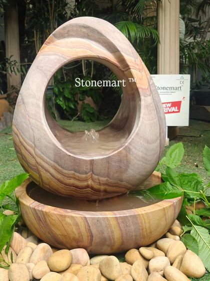 A different angle of the modern Rainbow Sandstone fountain, showing the smooth, hand-polished curves and the central water source.