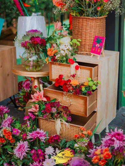 Flowers, flowers, and more flowers! This decor piece features a vintage-style cabinet with drawers overflowing with a vibrant mix of real flowers, adding a touch of rustic charm and abundant beauty.