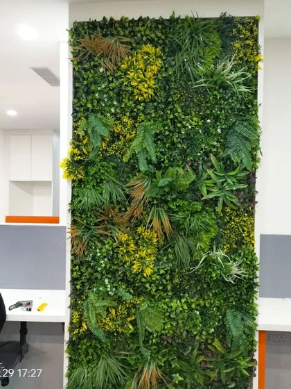 A close-up of the varied foliage used in one of our office green walls. We mix different leaf shapes, sizes, and colors, including yellow and brown accents, to achieve a highly realistic and natural look.