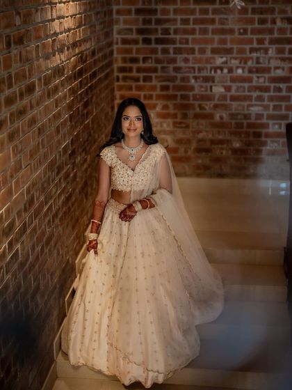 A full-length shot of her on the stairs, her lehenga flowing beautifully.