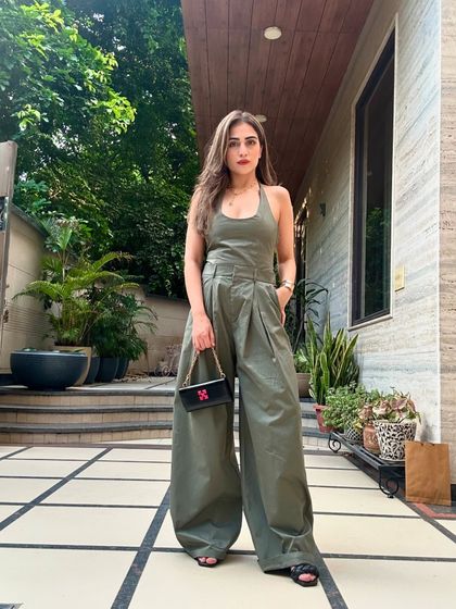 Another shot of the powerful olive green jumpsuit. The wide-leg silhouette is both comfortable and fashion-forward.