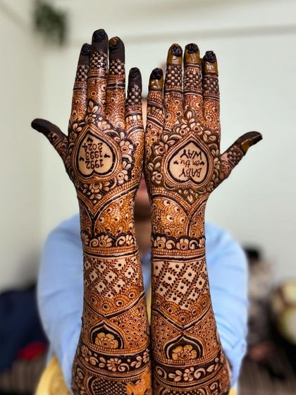 A fun pose showing off the baby shower mehendi, with the personalized hearts on full display.