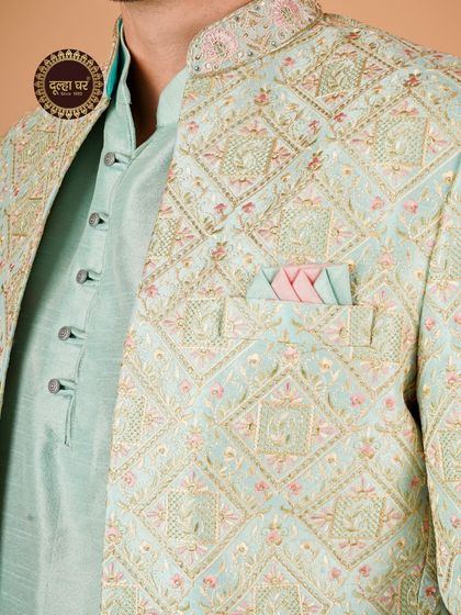 Pastel perfection for the modern groom. A close-up on a light blue and pink embroidered jacket, highlighting the intricate threadwork.
