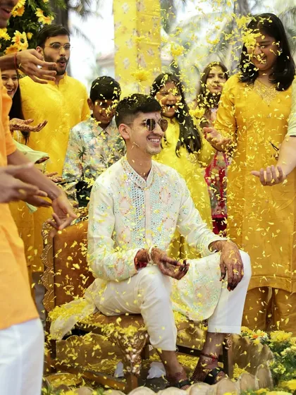 The Haldi ceremony is all about unrestrained happiness. Capturing the groom amidst a shower of flower petals, with a huge smile on his face, perfectly freezes that peak moment of celebration with friends and family.