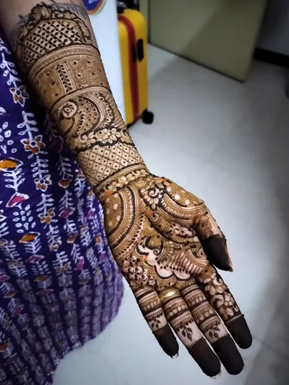 A side view of the family bridal mehendi, showing the flow of the design from the palm to the forearm. The details are crisp and clear, even on the sides.