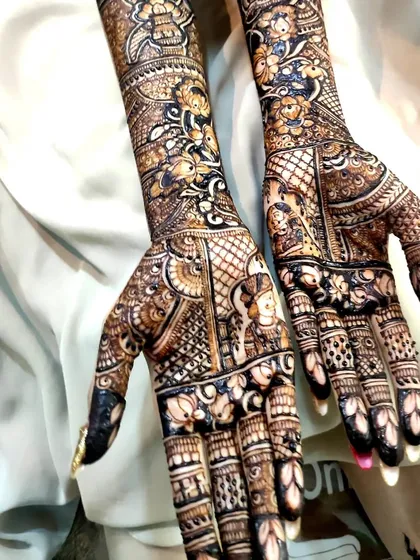 A beautiful bridal design that incorporates small, charming portraits of the bride and groom within the intricate floral patterns.