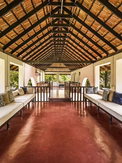 A comfortable and airy lounge area within one of our heritage buildings. The open-sided design allows for natural airflow and offers continuous views of the surrounding gardens, perfect for relaxing between treatments.