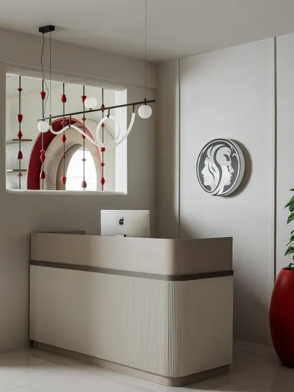 The reception desk is the first point of contact, designed to be clean, elegant, and welcoming. The minimalist desk is framed by the salon's logo and a window offering a peek into the colorful spaces within, setting the tone for the experience.