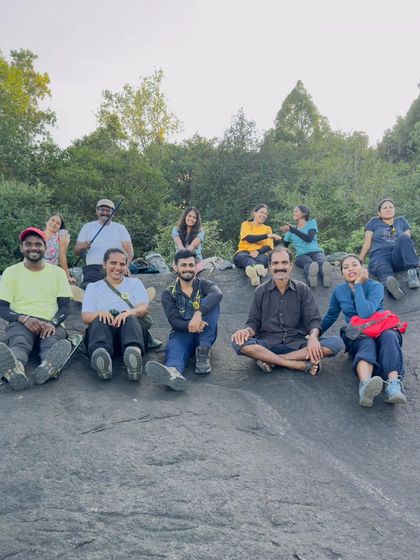 A group relaxing on a large, flat rock, sharing stories and laughter.