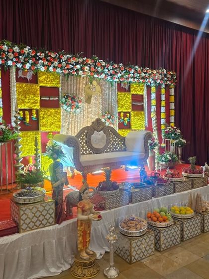 Another perspective of the checkered floral stage, highlighting the central sofa and the traditional brass lamps.