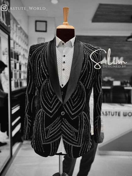 A mannequin displaying a black three-piece tuxedo with an intricate, geometric embroidered pattern. This is a perfect example of my modern, detailed tailoring.