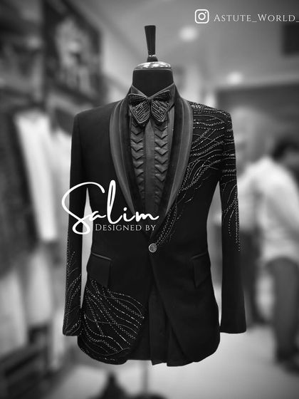 A mannequin displaying a black tuxedo jacket with abstract wave-like embroidery. The matching textured shirt and bow tie complete this avant-garde look.
