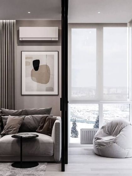 A living room with an attached sunroom or balcony, featuring a cozy beanbag. We design spaces that help you relax and enjoy the view.