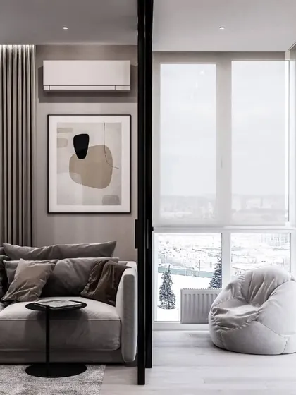 A living room with an attached sunroom or balcony, featuring a cozy beanbag. We design spaces that help you relax and enjoy the view.
