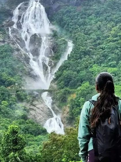 A solo trekker admiring the vastness of Dudhsagar Falls. Our trips are great for solo adventurers looking to connect with nature.