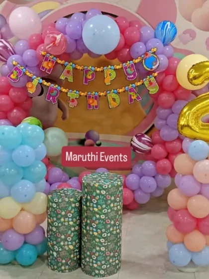 A pastel-colored balloon arch for a second birthday. The soft shades of pink, purple, and blue create a gentle and pretty atmosphere.