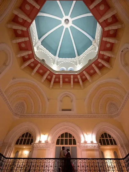 An artistic shot looking up at the magnificent dome ceiling, with the couple as a small, intimate detail. This shows a creative approach to wedding photography.