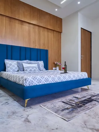 Another view of this striking bedroom, showing the seamless floor-to-ceiling wooden wardrobe that complements the accent wall. The polished concrete floor adds an industrial-chic element.