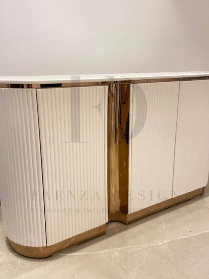 A custom-designed console for a foyer, featuring a curved silhouette, white fluted doors, and a rose-gold metallic finish. It's a perfect blend of modern design and classic glamour.