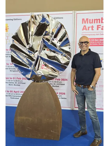 Here I am with "Eclipse," a freestanding sculpture that contrasts a rustic Corten steel base with a polished, crumpled stainless steel top. It represents the idea that even when light is momentarily obscured, its true nature shines through.