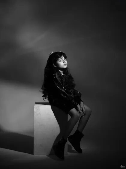 A dramatic, low-angle shot in black and white. This cinematic portrait of Pahal highlights her presence and poise, using light and shadow to create a powerful image.