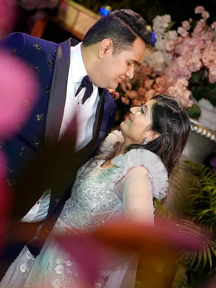 A creative, romantic shot of the couple dancing at their engagement, framed by flowers. This adds an artistic and dreamy feel to the photo.