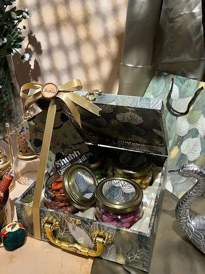 A beautiful trunk-style box with a green leaf pattern and a silver swan decor piece. This hamper is perfect for someone who loves nature-inspired aesthetics.
