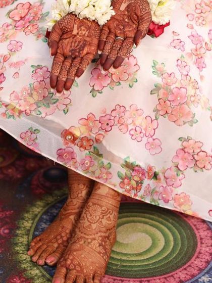 A beautiful shot of the bride's hands and feet, with her floral lehenga providing a lovely backdrop.