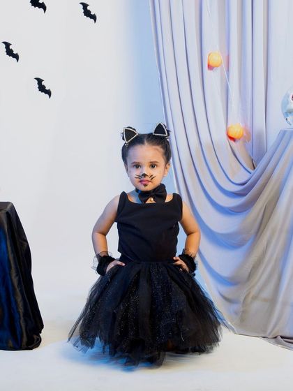 A full-length shot of the child in the black cat costume.