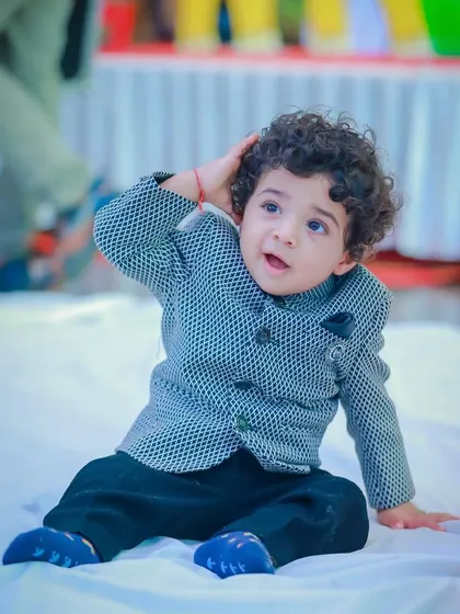 A playful moment in his formal best. The lightweight fabric and soft lining of our custom jackets mean he can move, play, and enjoy the celebration without any fuss.