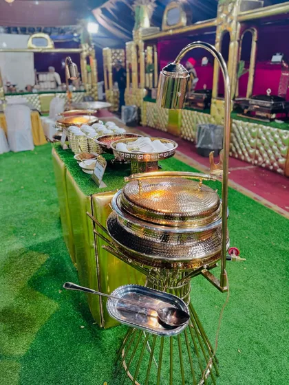 A close-up of the ornate, hammered-gold serving dishes used at my Mughlai counter, adding a touch of royalty to the buffet.