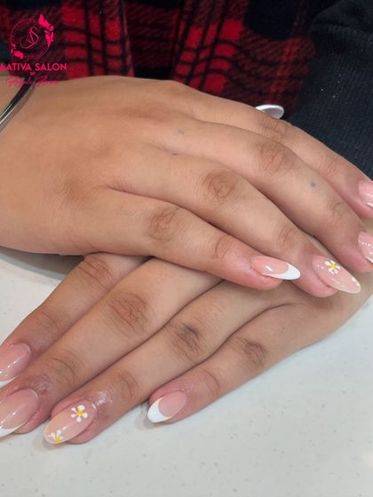A delicate and sweet take on the French manicure. We added tiny, hand-painted daisies to these classic French tips for a subtle and charming detail.