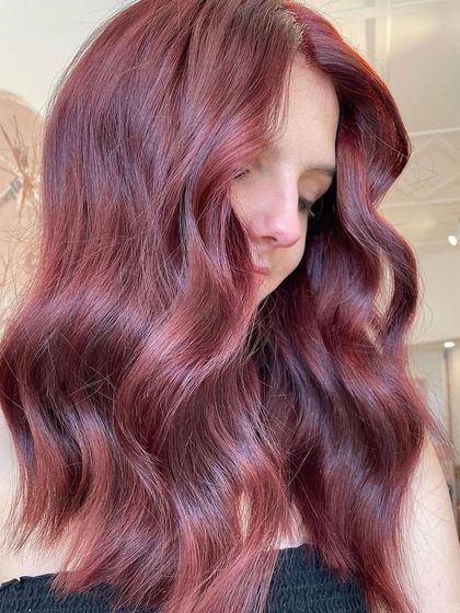 This gorgeous burgundy hair was created by blending different red and violet tones. The result is a deep, rich color that looks incredibly luxurious and is perfect for wavy hair.