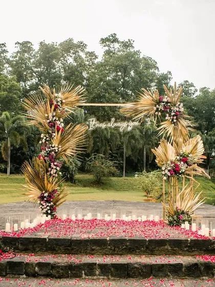 The proposal stage ready for the big moment, with a carpet of red rose petals and candles lining the steps.