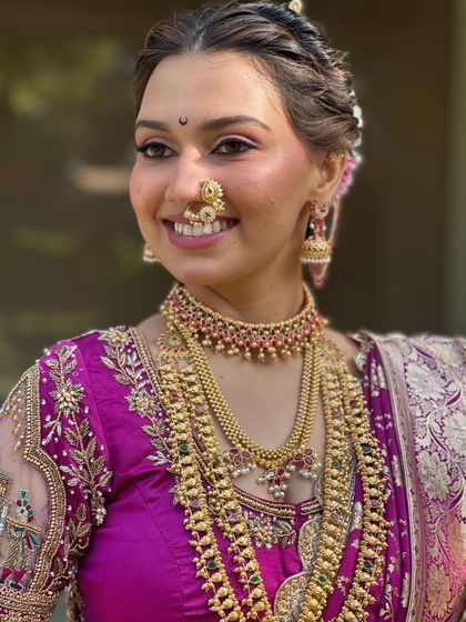 A close-up of the bride's happy smile and intricate Peshwai jewelry.