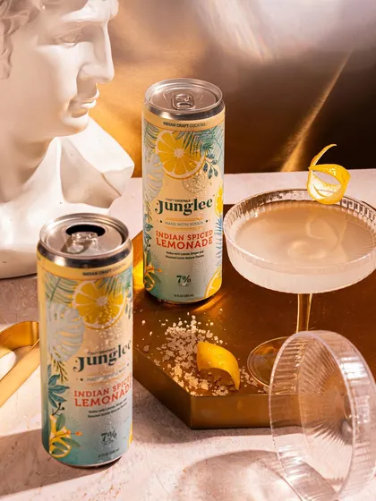 An elegant, artistic setup for Junglee's Indian Spiced Lemonade, using classic sculptural elements and sophisticated glassware to create a high-end cocktail bar vibe.