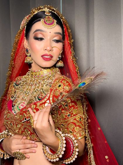 A creative shot with a peacock feather, adding a touch of artistry to the bridal portrait.