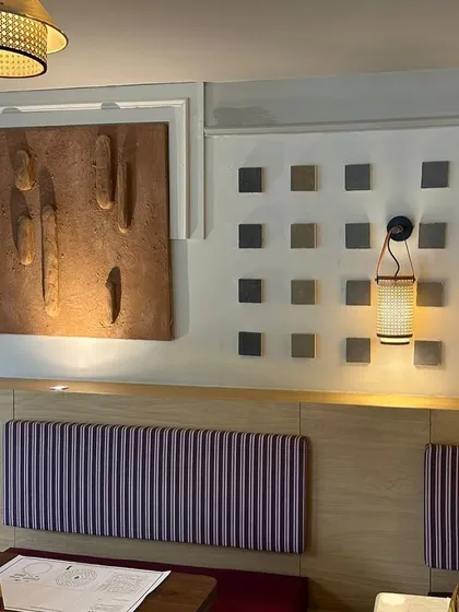 The two different styles of artwork installed side-by-side at the Agra cafe, complemented by a grid of small textured squares.