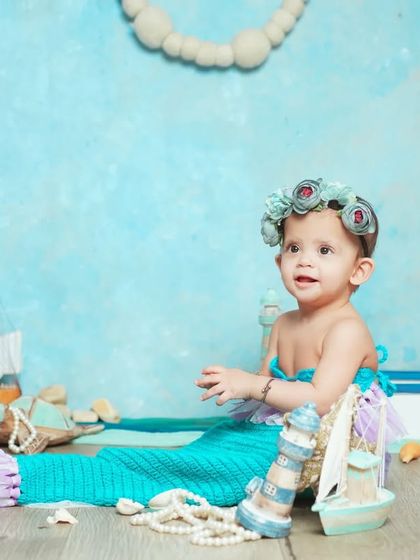 A magical mermaid theme. We provide the tail and a beautiful ocean-inspired set to turn your baby into a cute little mermaid for a day.