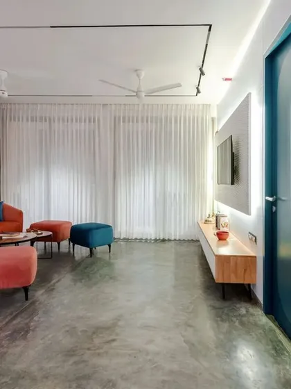 A wide shot of the T7 T8 living room, showing the balance between the bold sofa, the sleek media unit, and the soft light from the large windows.