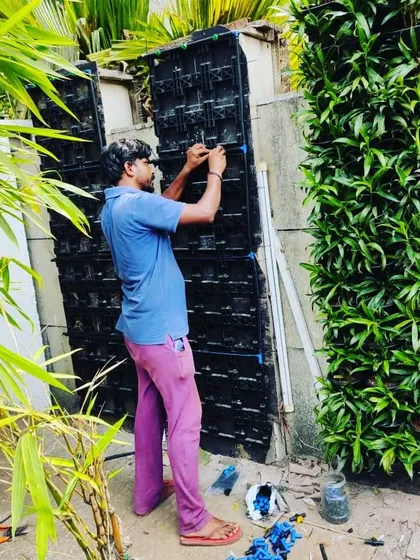 Our team member at work, carefully assembling the modular panels for a vertical garden. We ensure every panel is securely fixed and ready for planting.