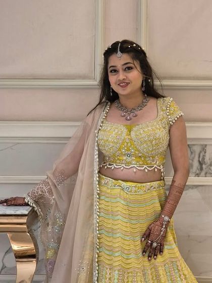 A closer look at the intricately beaded blouse of the pastel yellow lehenga. Paired with a matching necklace, this rental outfit provides a complete and polished look with minimal effort.